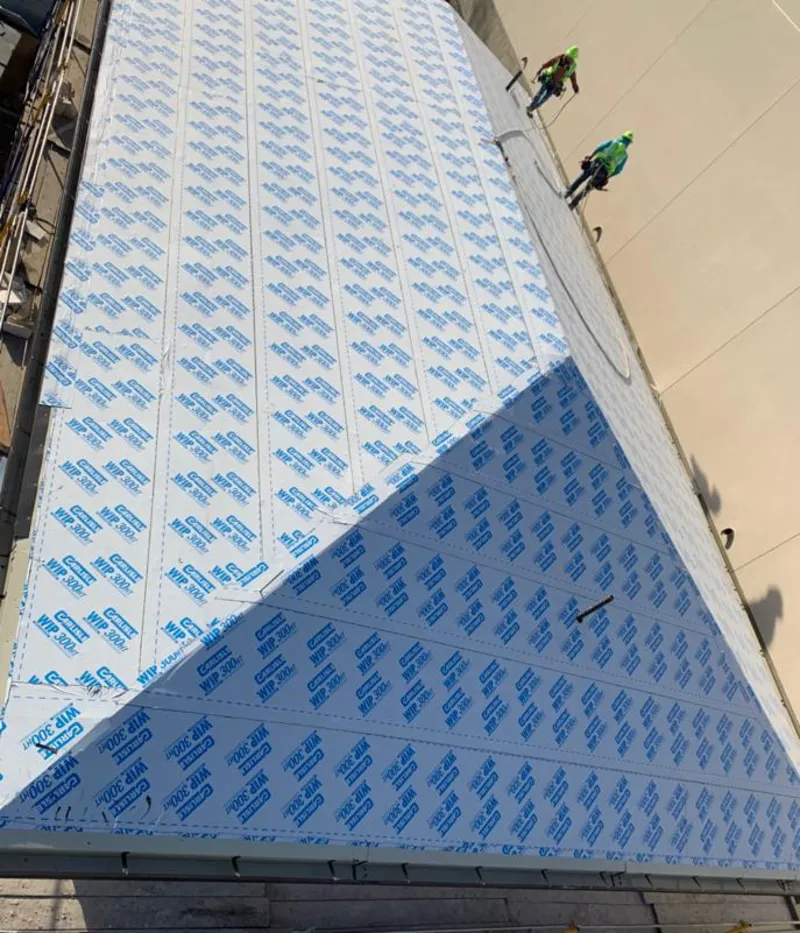 Professional roofers installing underlayment on a metal roof in New Rochelle